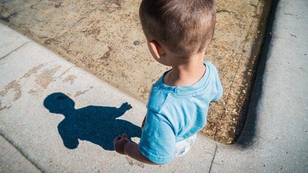 young boy looking at his shadow