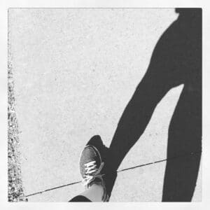 A sneaker stepping on a crack in the sidewalk