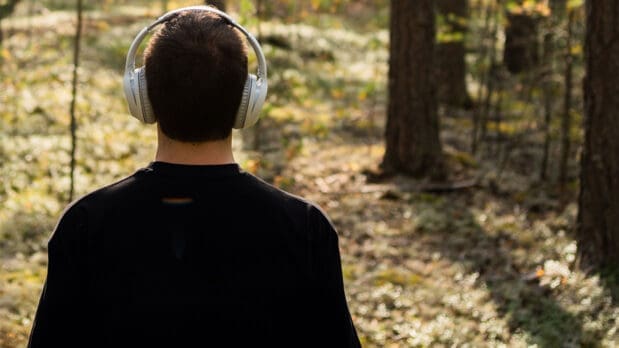 Man with headphones in a quiet forest