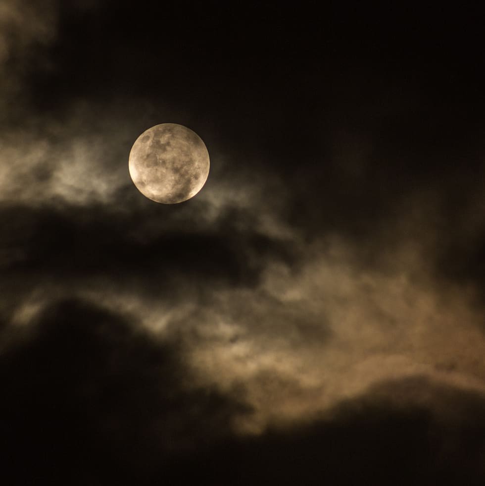 clouds obscuring a full moon