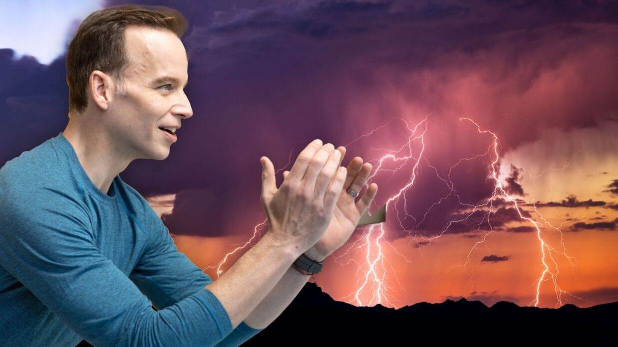 James Donegan in front of a lightening bolt breaking the night sky.