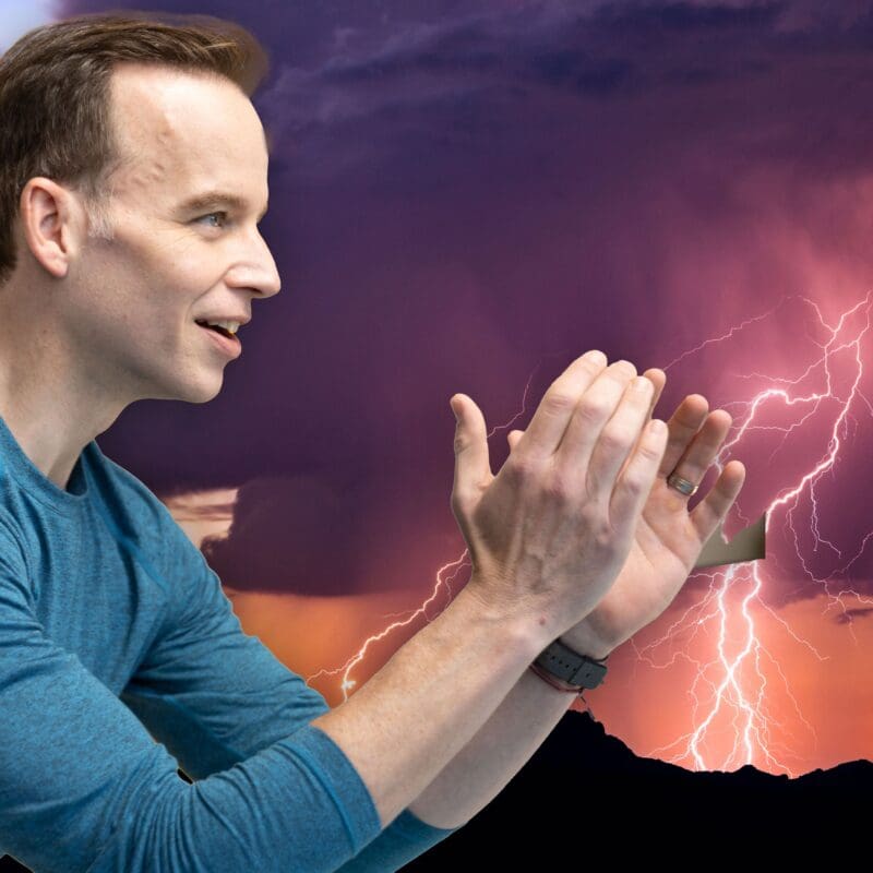 James Donegan in front of a lightening bolt breaking the night sky.