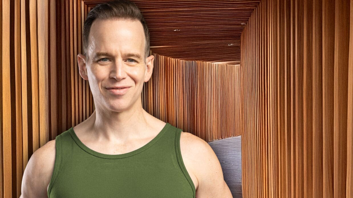 James Donegan in front of a long hallway made of wooden slats